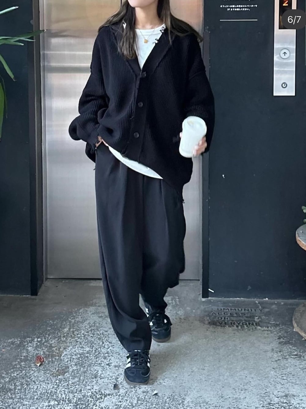 ブラック系のカーディガン/ボレロ、ブラック系のスラックスを着用したレディースの春コーディネートの2枚目の写真