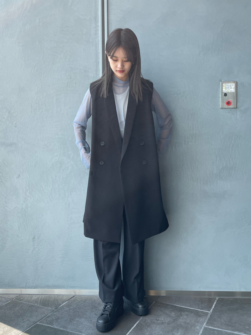 ブラック系のベスト、ホワイト系のキャミソール、ブラック系のその他パンツを着用したレディースの秋コーディネートの2枚目の写真