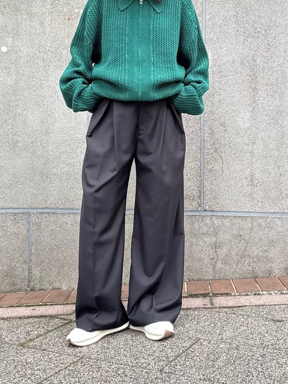 グリーン系のニット/セーター、グレー系のスラックスを着用したレディースの冬コーディネートの5枚目の写真