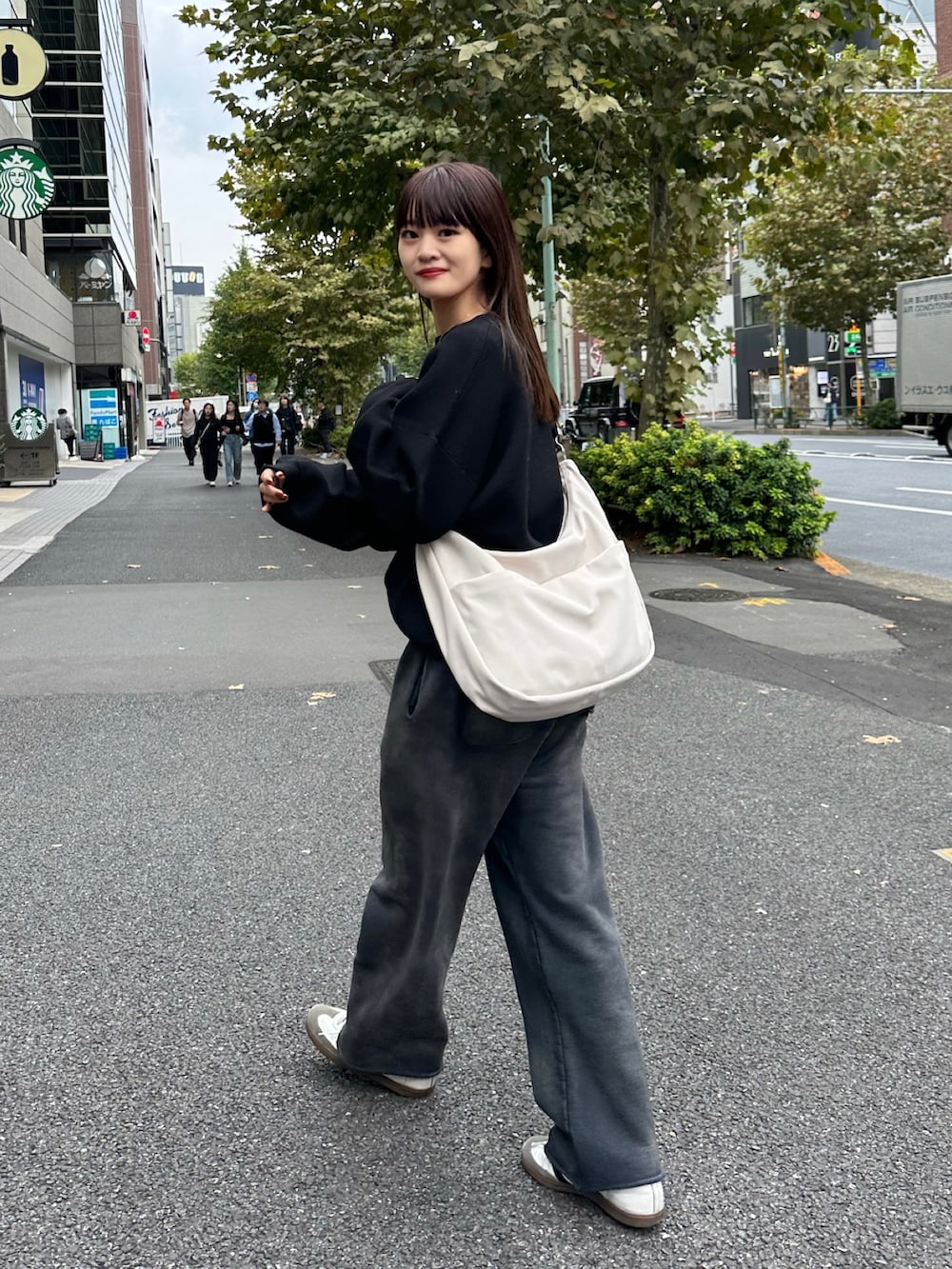 ホワイト系のバッグ、ホワイト系のスニーカー、ブラック系のニット/セーターを着用したレディースの秋コーディネートの3枚目の写真