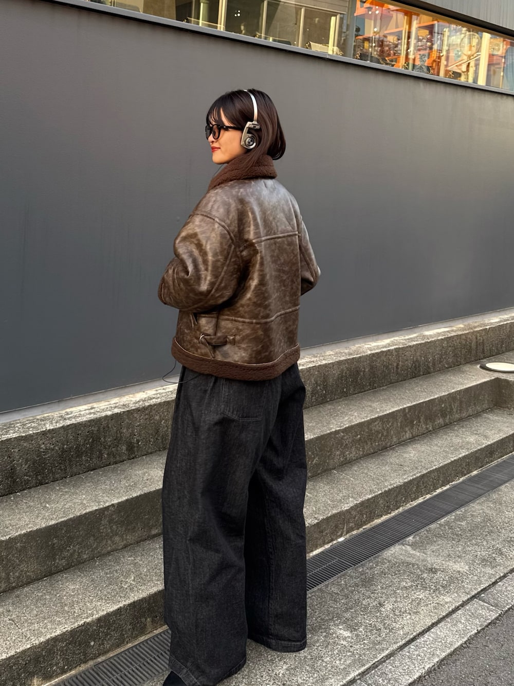 ブラウン系のブルゾン、ブラック系のデニムパンツを着用したレディースの秋コーディネートの9枚目の写真