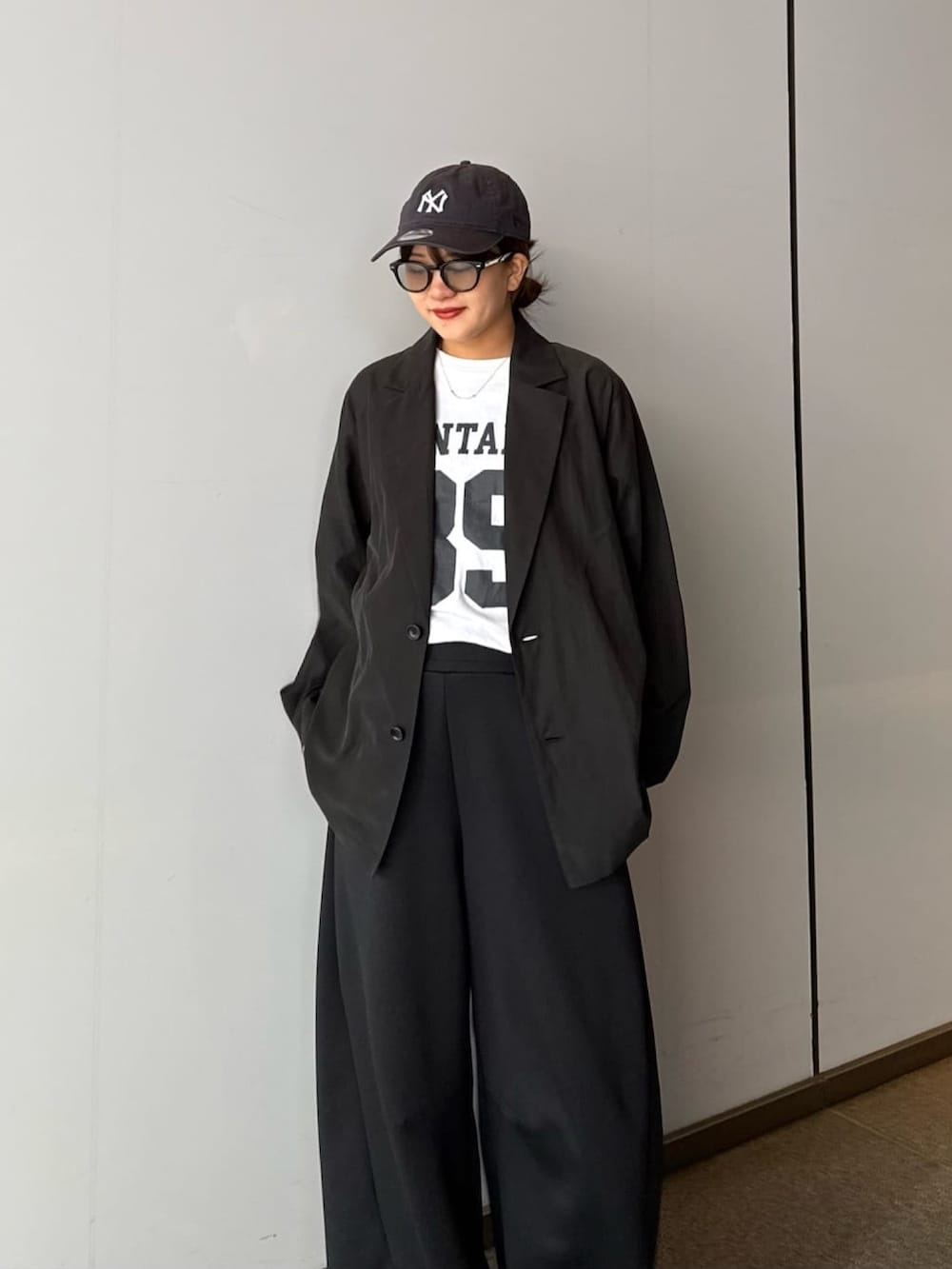 グレー系のその他パンツ、ブラック系のシャツ/ブラウス、ブラック系のサングラスを着用したレディースの春コーディネートの2枚目の写真