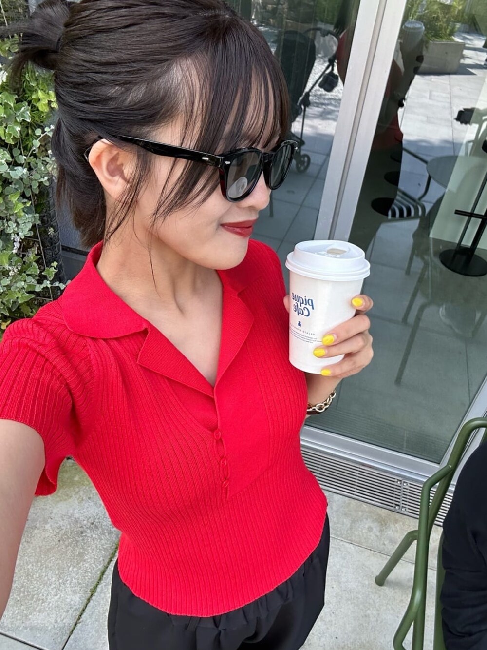 レッド系のニット/セーター、グレー系のパンツ、グレー系のサングラスを着用したレディースの夏コーディネートの4枚目の写真