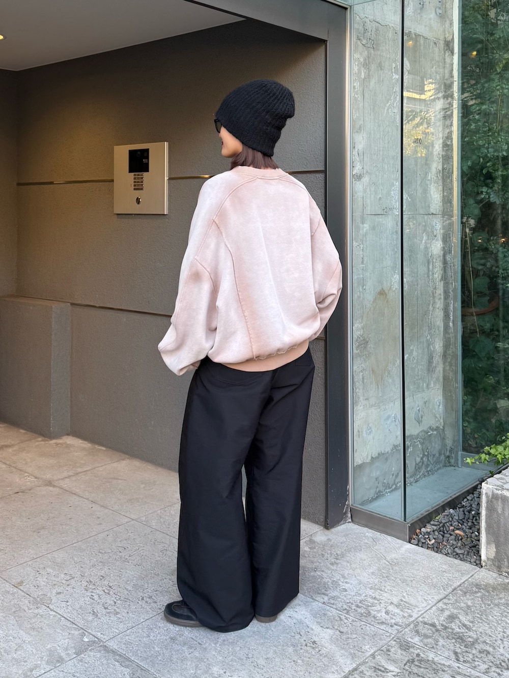 ベージュ系のスウェット、ブラック系のスラックス、ブラック系のサングラスを着用したレディースの冬コーディネートの3枚目の写真