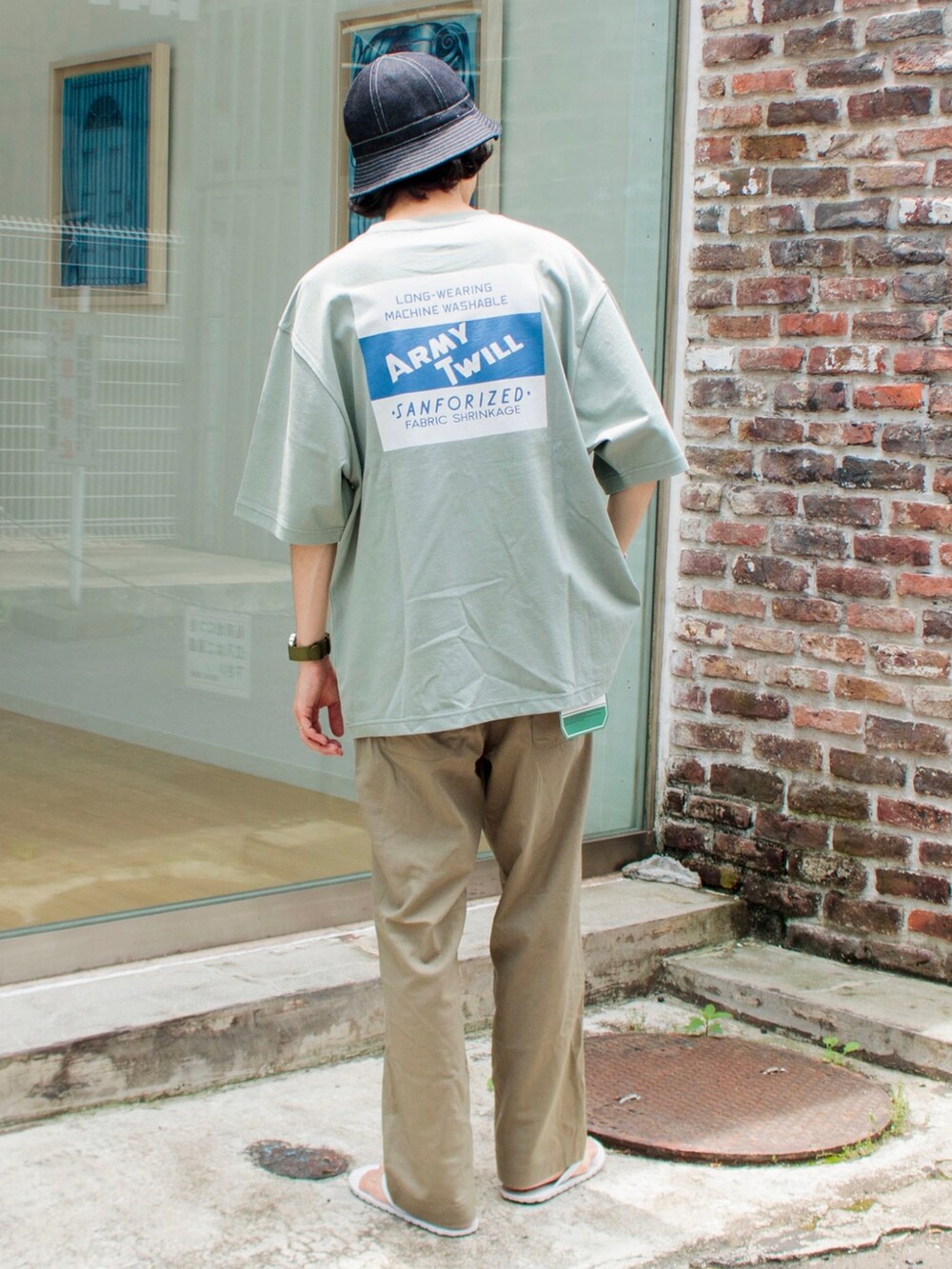 グレー系のTシャツ/カットソー、ベージュ系のその他パンツ、ホワイト系のサンダルを着用したメンズの夏コーディネートの2枚目の写真