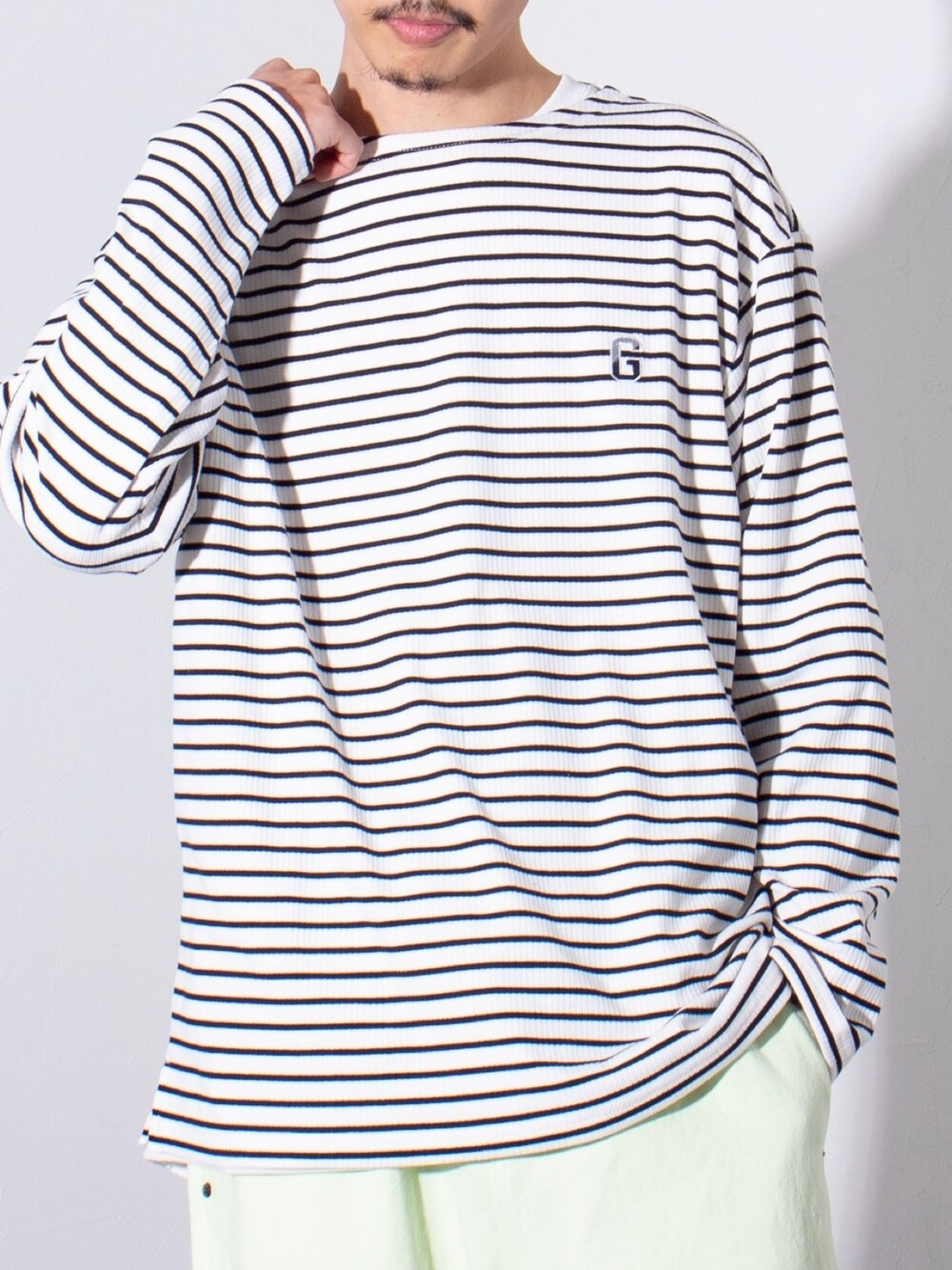 ブラック系のTシャツ/カットソー、グリーン系のデニムパンツを着用したメンズの冬コーディネートの2枚目の写真