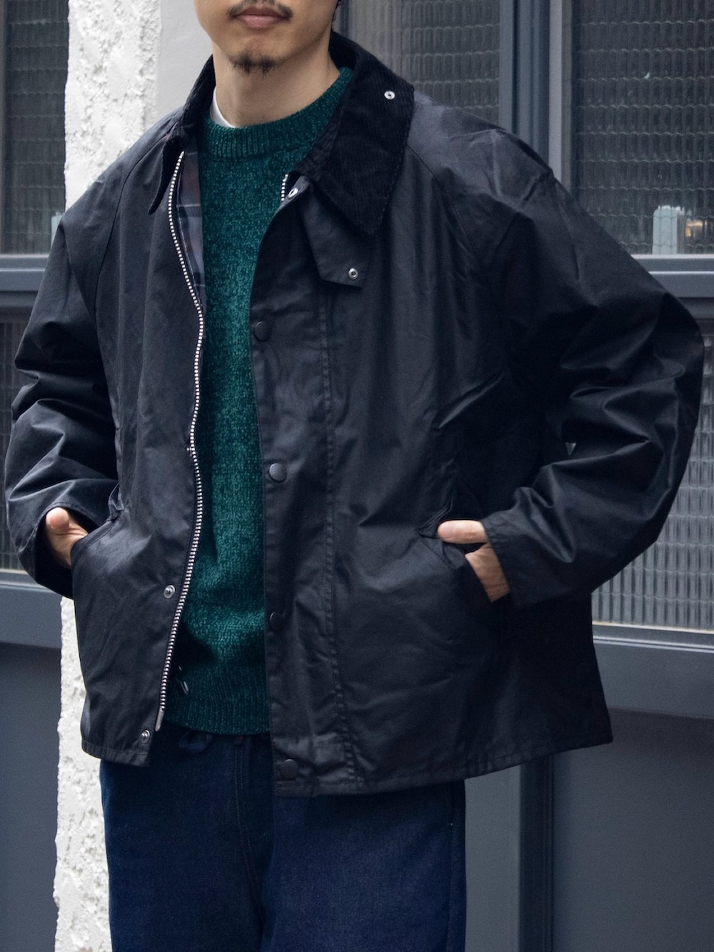 ブラック系のブルゾン、グリーン系のニット/セーター、ブルー系のデニムパンツを着用したメンズの秋コーディネートの3枚目の写真