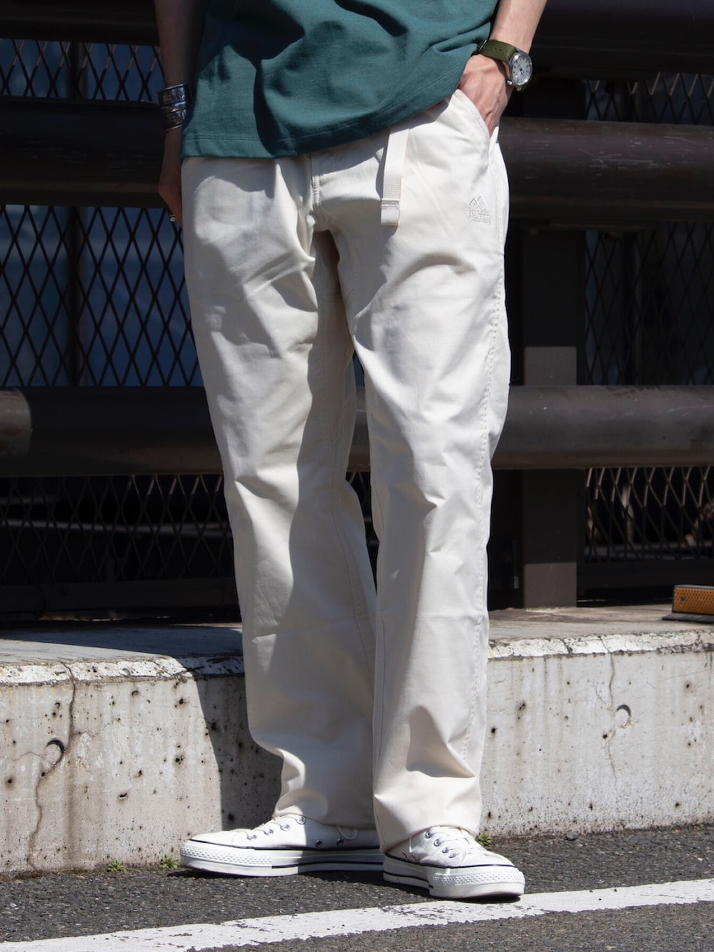 グリーン系のTシャツ/カットソー、ホワイト系のデニムパンツ、ホワイト系のスニーカーを着用したメンズの春コーディネートの3枚目の写真