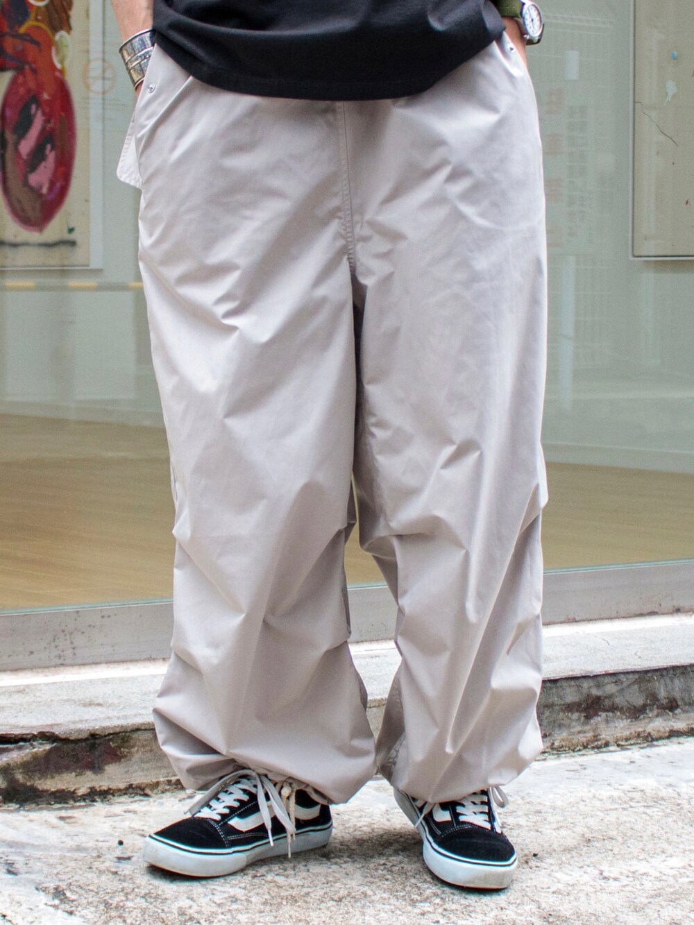 グレー系のTシャツ/カットソー、ベージュ系のその他パンツ、ブラック系のスニーカーを着用したメンズの夏コーディネートの4枚目の写真