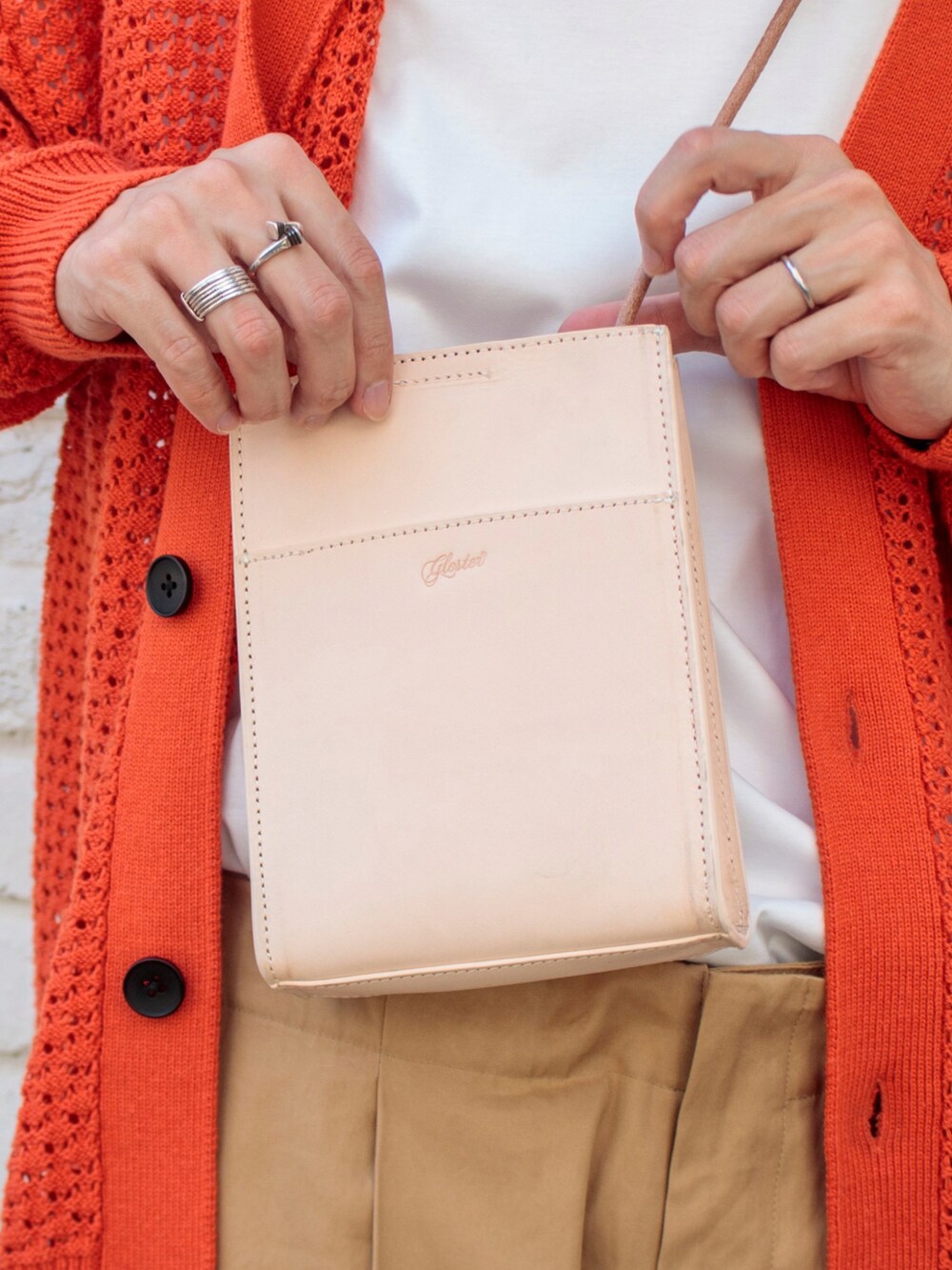 オレンジ系のカーディガン/ボレロ、ベージュ系のショルダーバッグ、ブラック系のサンダルを着用したメンズの夏コーディネートの3枚目の写真