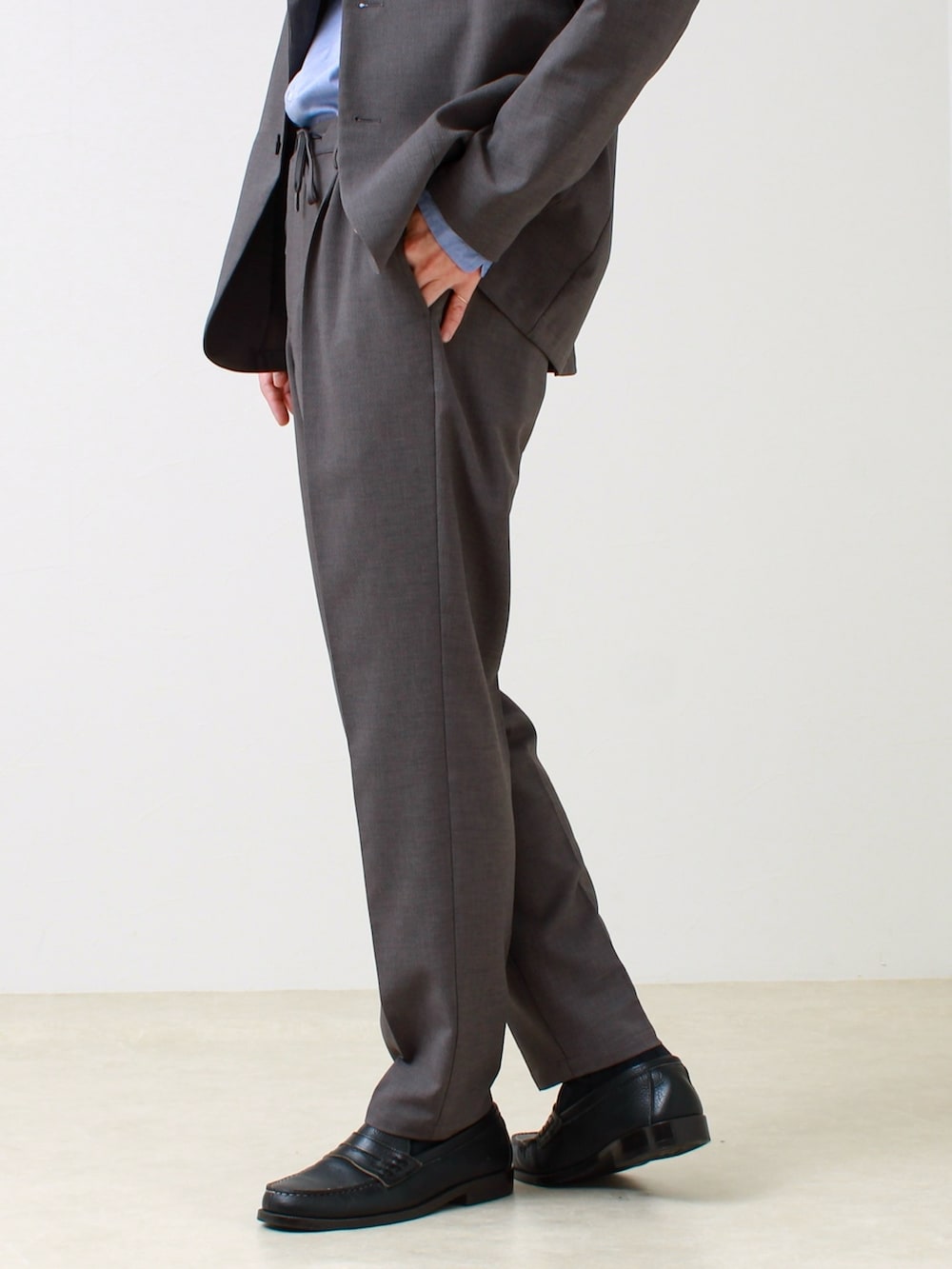 グレー系のテーラードジャケット、ブルー系のシャツ/ブラウス、グレー系のその他パンツを着用したメンズの春コーディネートの4枚目の写真