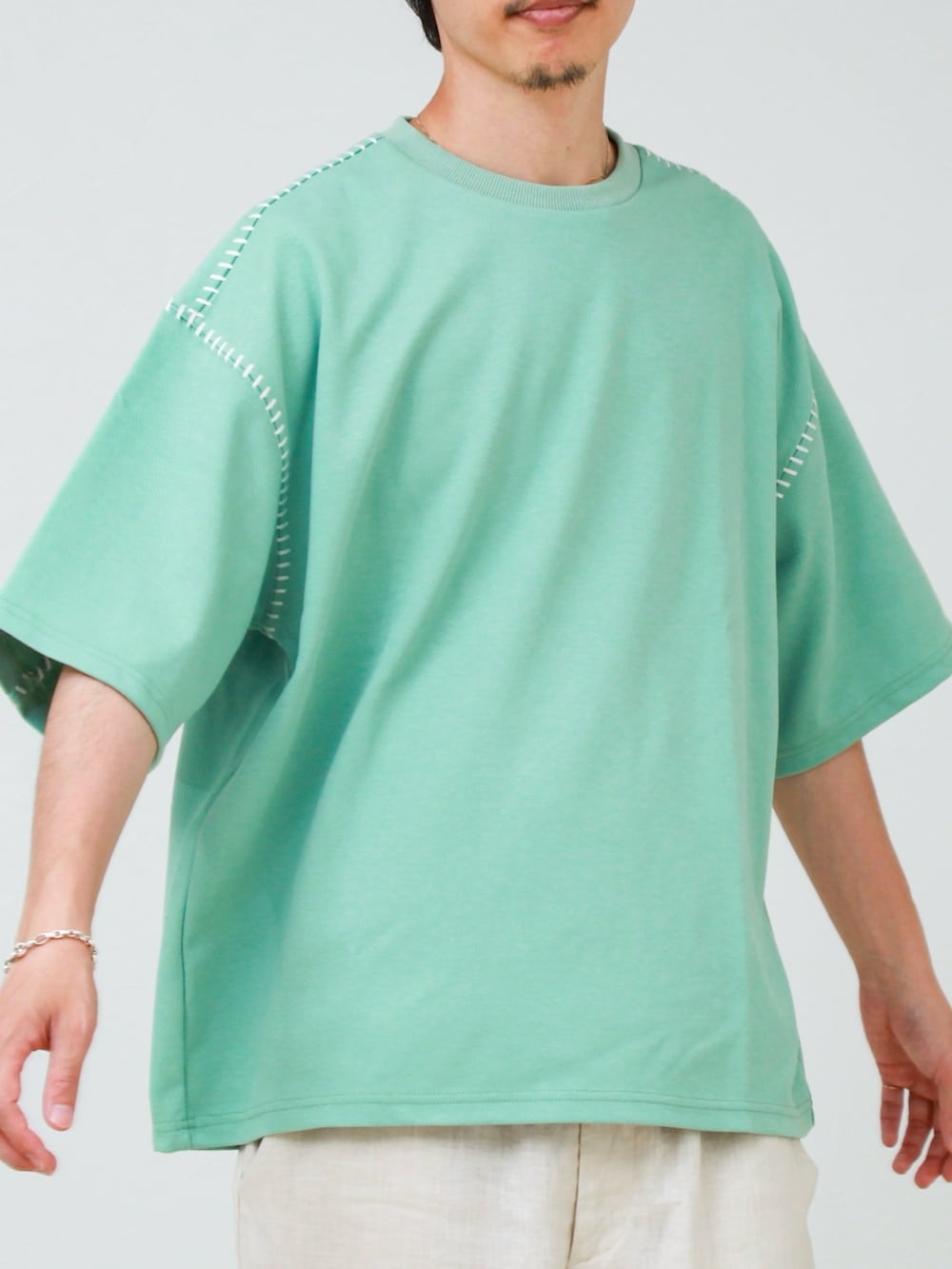 グリーン系のTシャツ/カットソー、ホワイト系のその他パンツ、ホワイト系のスニーカーを着用したメンズの夏コーディネートの2枚目の写真