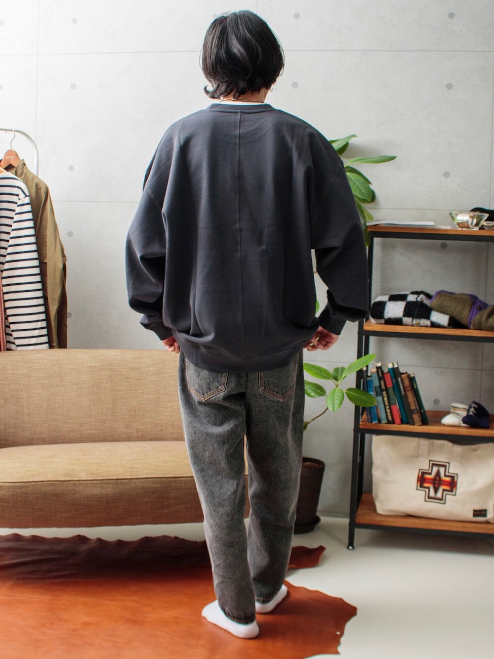 グレー系のスウェット、ブラック系のデニムパンツを着用したメンズの夏コーディネートの2枚目の写真