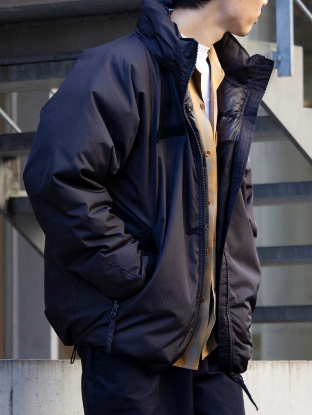 ブラック系のダウンジャケット/コート、イエロー系のシャツ/ブラウスを着用したメンズの秋コーディネートの2枚目の写真