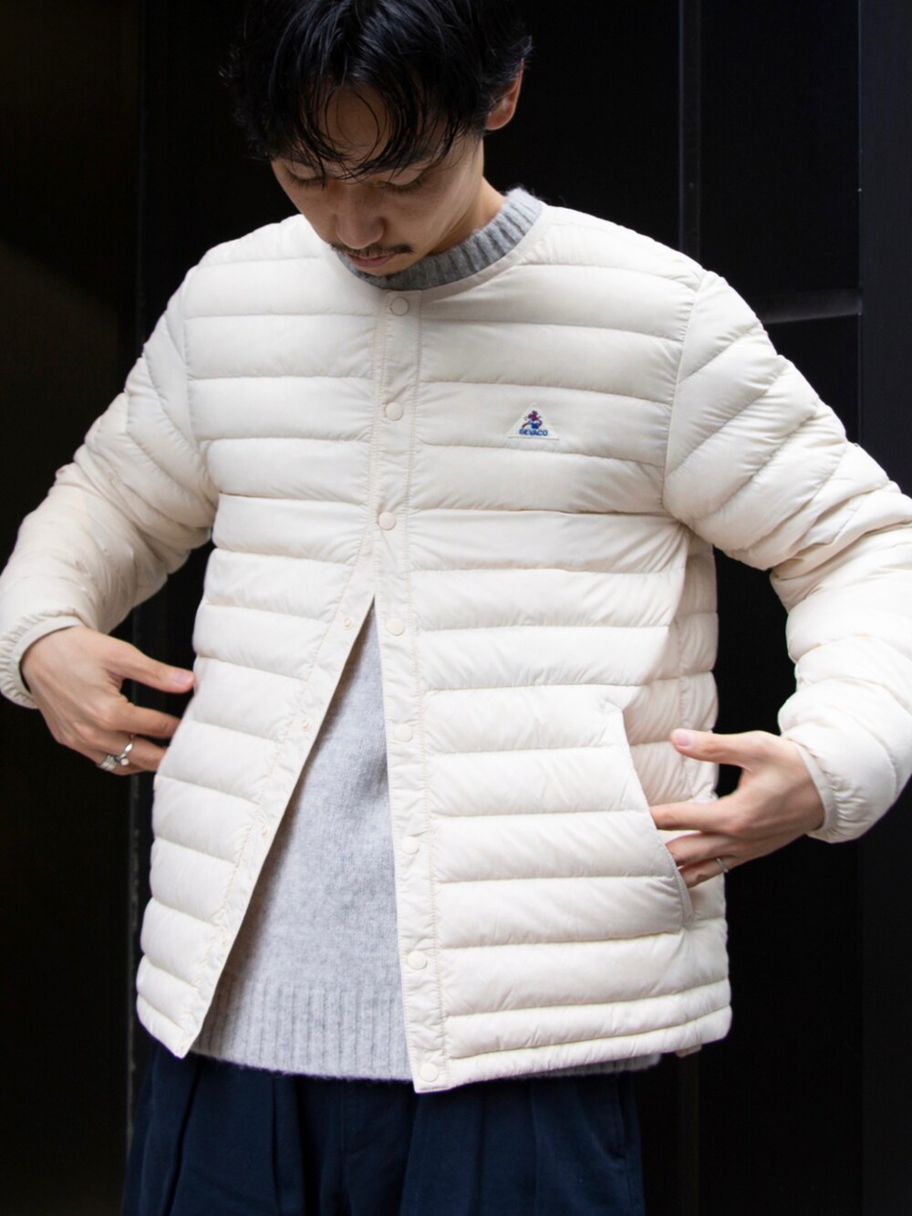 ホワイト系のダウンジャケット/コート、ブルー系のチノパンツ、ブラック系のスニーカーを着用したメンズの秋コーディネートの3枚目の写真