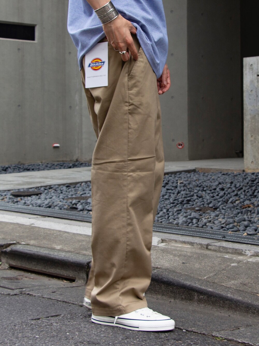 ブルー系のTシャツ/カットソー、ベージュ系のチノパンツ、ホワイト系のスニーカーを着用したメンズの夏コーディネートの3枚目の写真