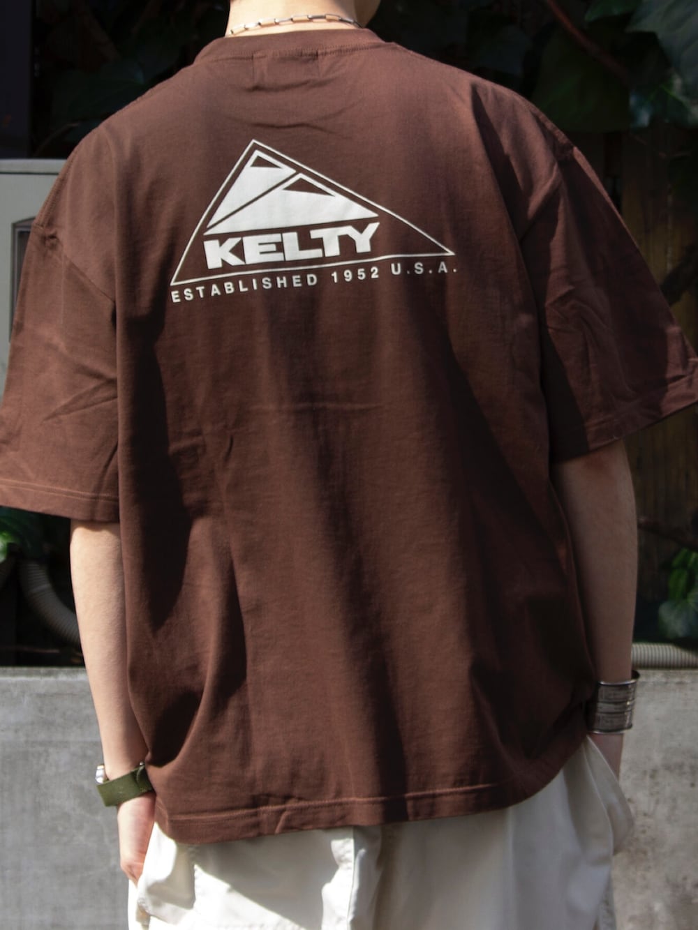ブラウン系のTシャツ/カットソー、ホワイト系のその他パンツ、ブラック系のショルダーバッグを着用したメンズの春コーディネートの3枚目の写真