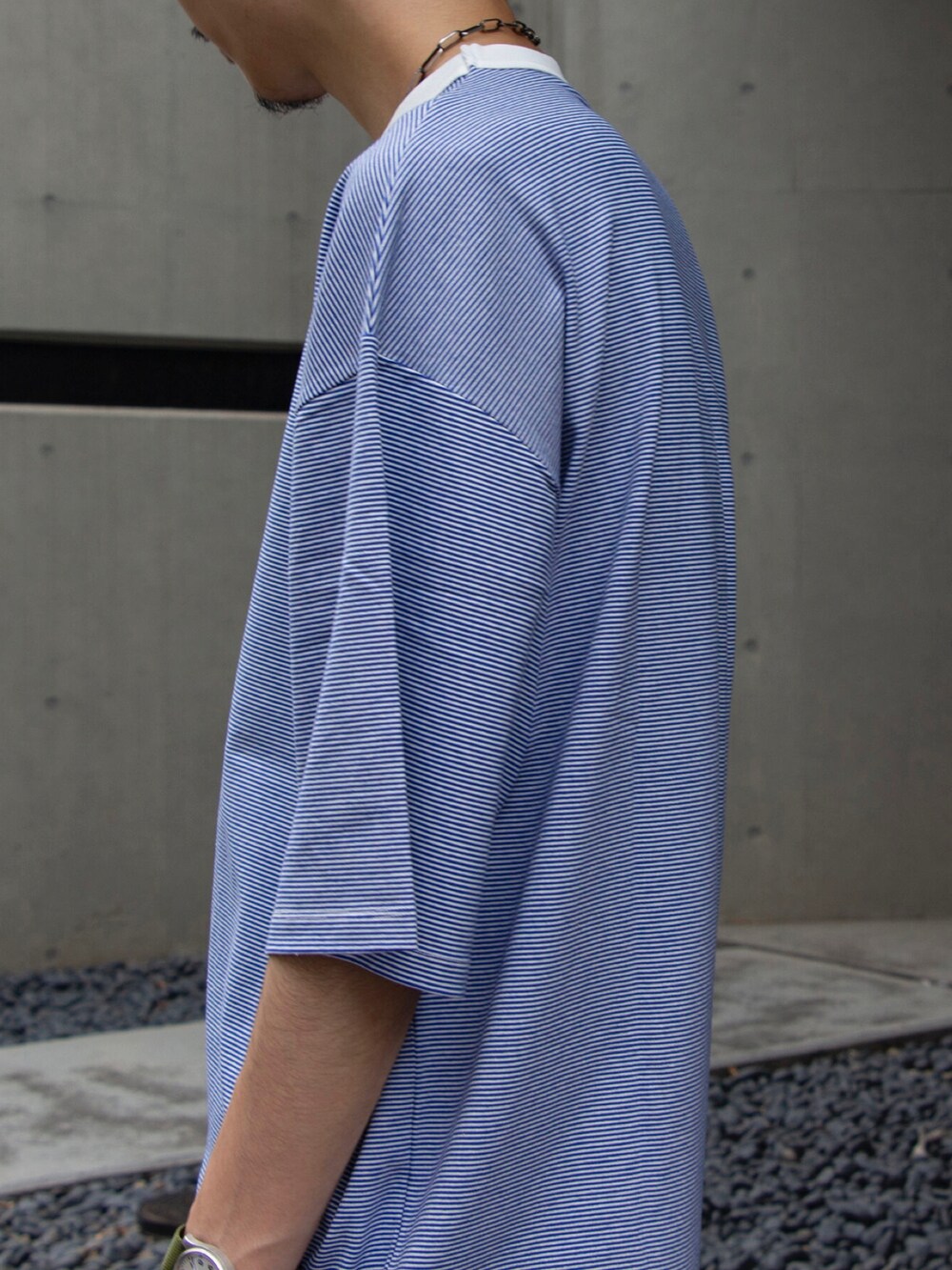 ブルー系のTシャツ/カットソー、ベージュ系のチノパンツ、ホワイト系のスニーカーを着用したメンズの夏コーディネートの5枚目の写真