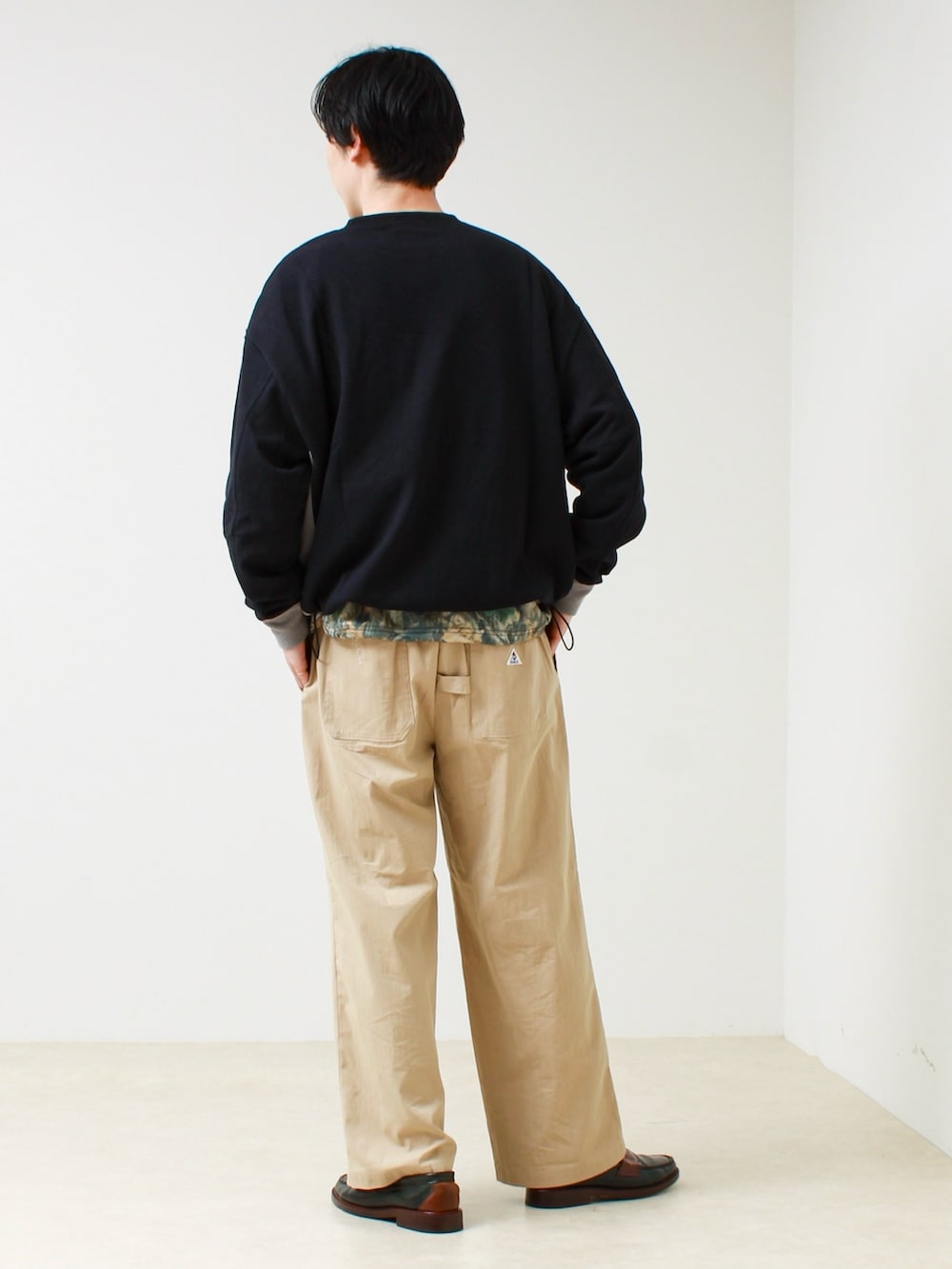 ブラック系のTシャツ/カットソー、その他のスウェット、ベージュ系のその他パンツを着用したメンズの春コーディネートの3枚目の写真