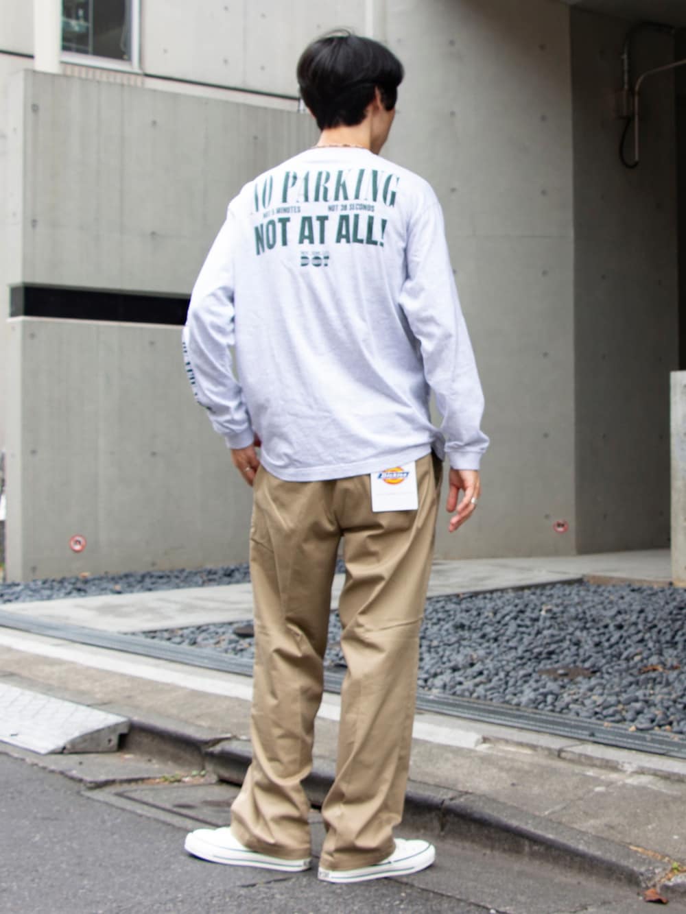 グレー系のTシャツ/カットソー、ベージュ系のチノパンツ、ホワイト系のスニーカーを着用したメンズの夏コーディネートの2枚目の写真