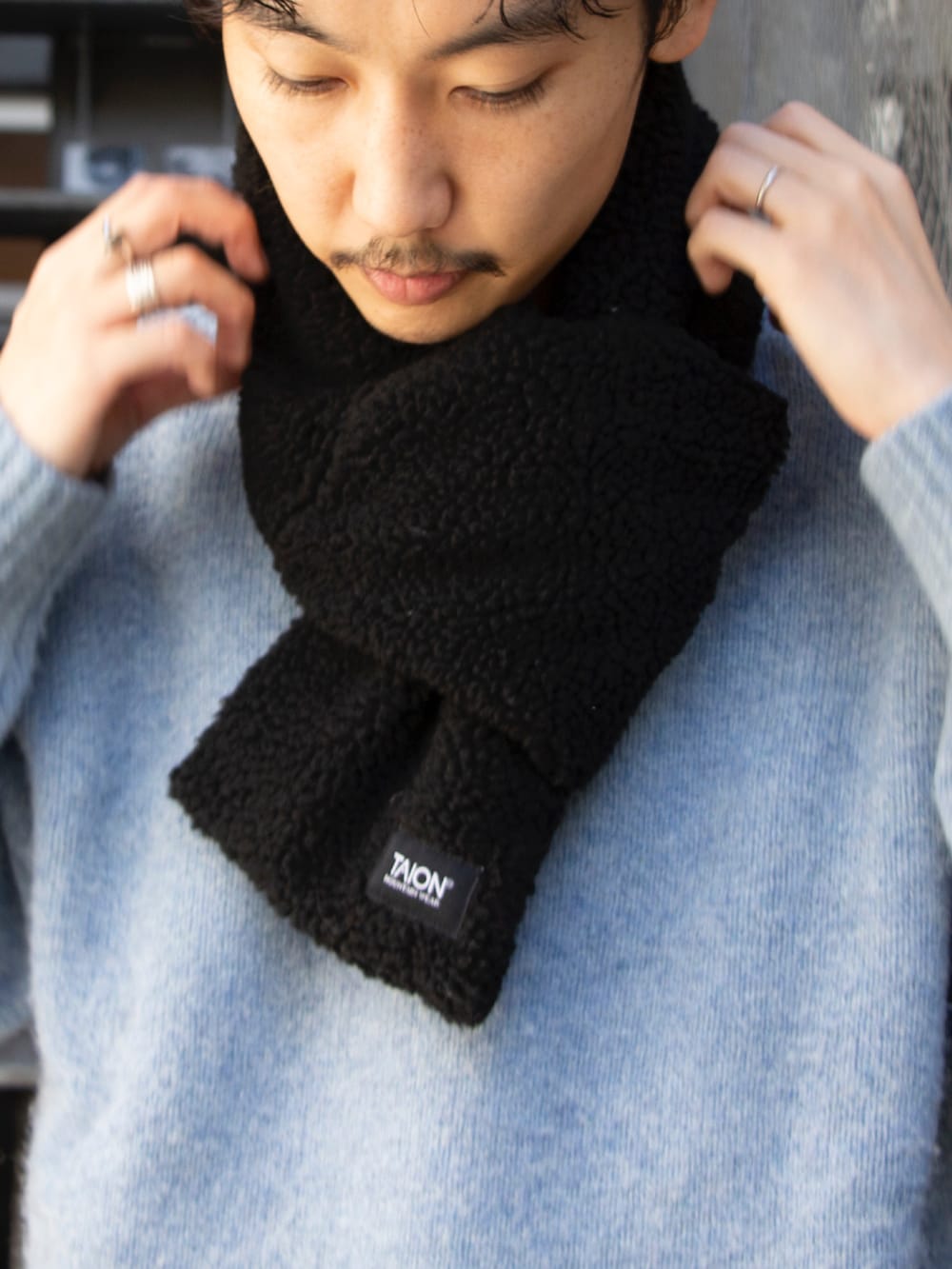 ブルー系のニット/セーター、ブルー系のチノパンツ、ブルー系のスニーカーを着用したメンズの秋コーディネートの4枚目の写真