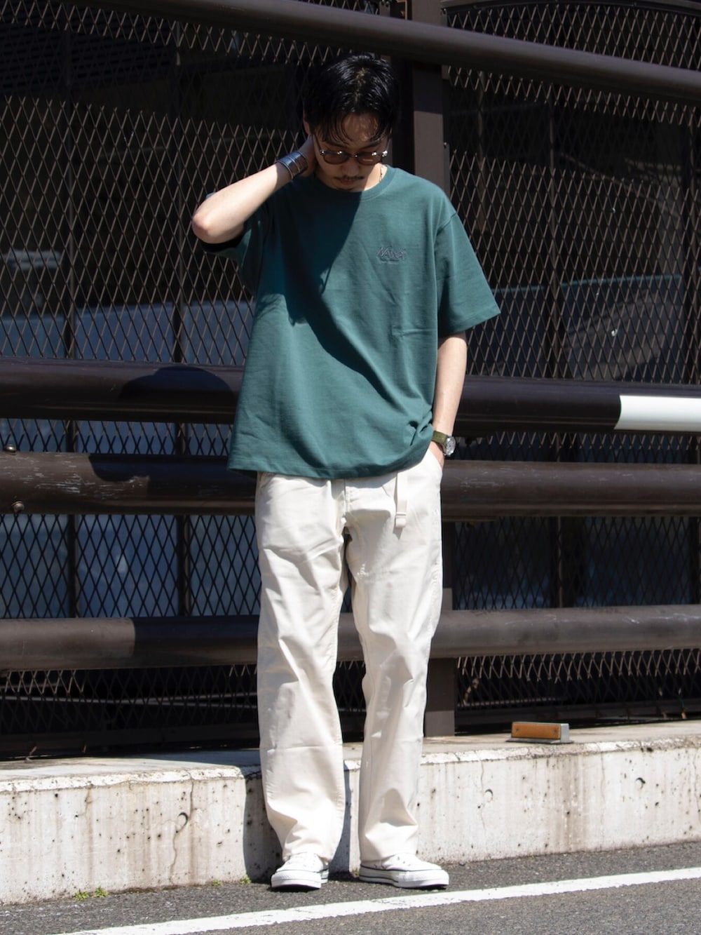 グリーン系のTシャツ/カットソー、ホワイト系のデニムパンツ、ホワイト系のスニーカーを着用したメンズの春コーディネートの2枚目の写真