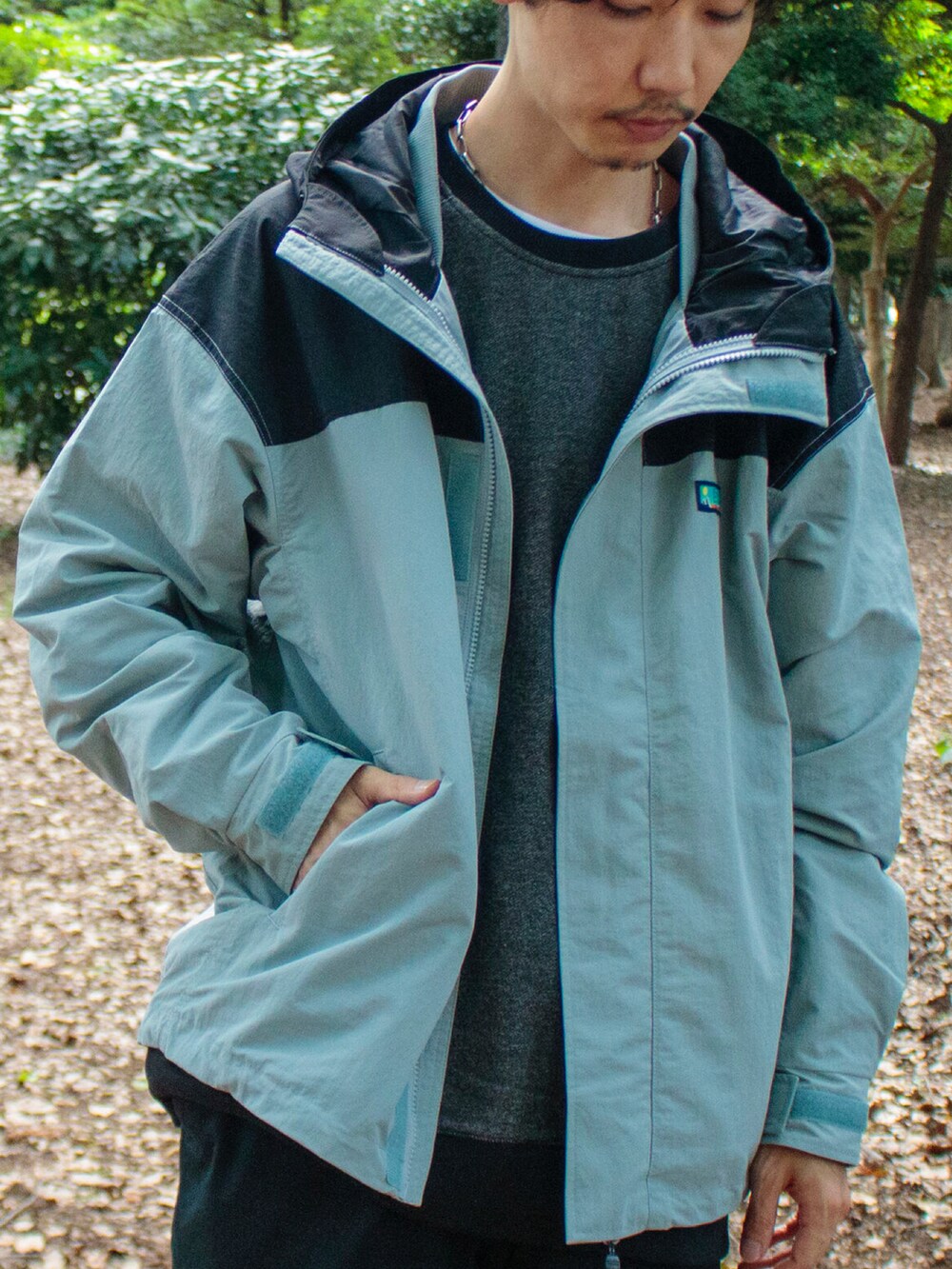 ブルー系のブルゾン、ブラック系のスウェット、ブラック系のチノパンツを着用したメンズの秋コーディネートの3枚目の写真