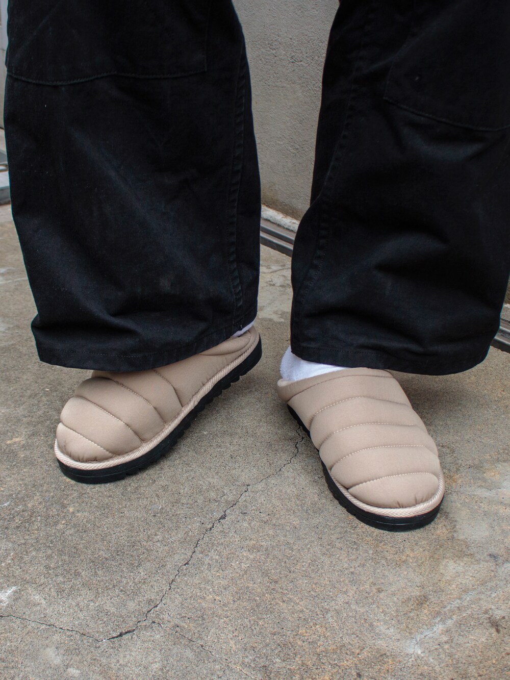 オレンジ系のベスト、グレー系のスウェット、ベージュ系のサンダルを着用したメンズの秋コーディネートの5枚目の写真