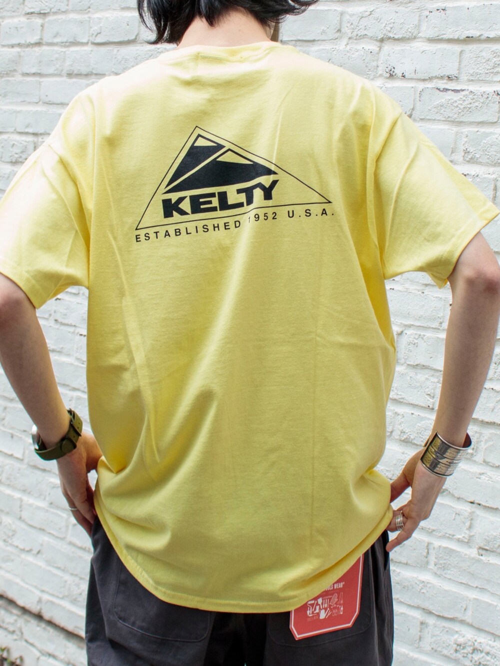 「大人カジュアル、シンプルコーデ、キャップ、春夏コーデ、夏コーデ、ブーツ、Tシャツ、休日スタイル、ケルティ、gloster、ビッグシルエット、シェフパンツ、FREDY&GLOSTER、イエロー」｜「KELTYの【KELTY/ケルティ】別注バックプリント ビッグシルエットショートスリーブTシャツ（Tシャツ/カットソー、イエロー系）」を使った、須山さん（メンズ・177cm）の春コーディネートの3枚目の写真