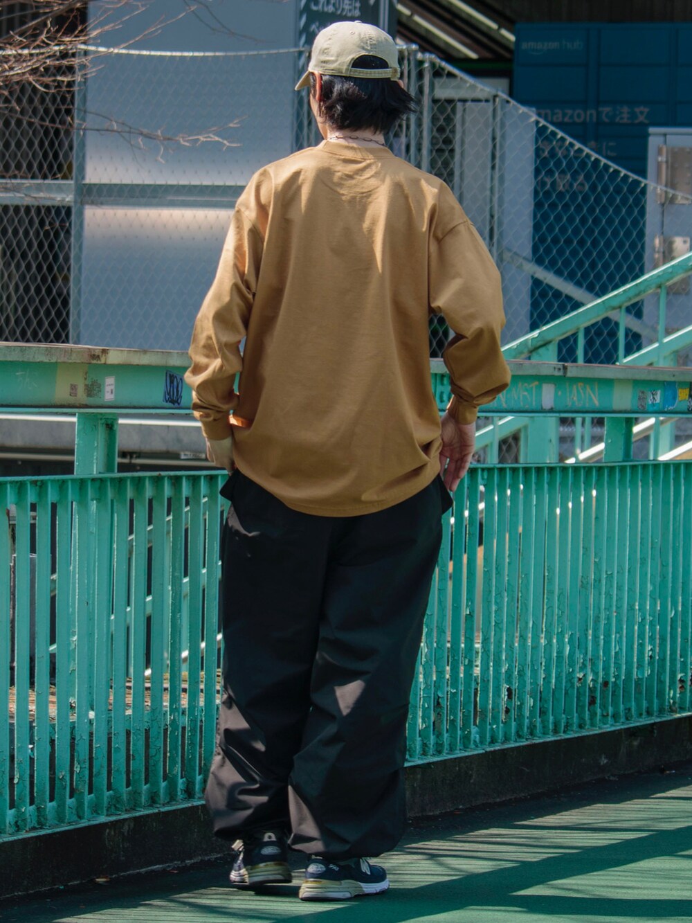 イエロー系のTシャツ/カットソー、ブラック系のその他パンツ、ブルー系のスニーカーを着用したメンズの春コーディネートの2枚目の写真