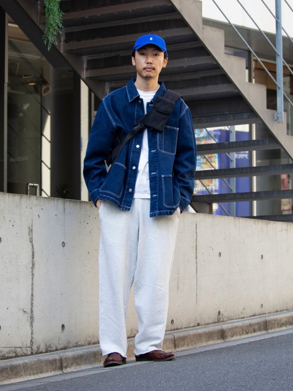 ブラック系のショルダーバッグ、ホワイト系のスウェットパンツ、ブルー系のカバーオールを着用したメンズの秋コーディネートの2枚目の写真