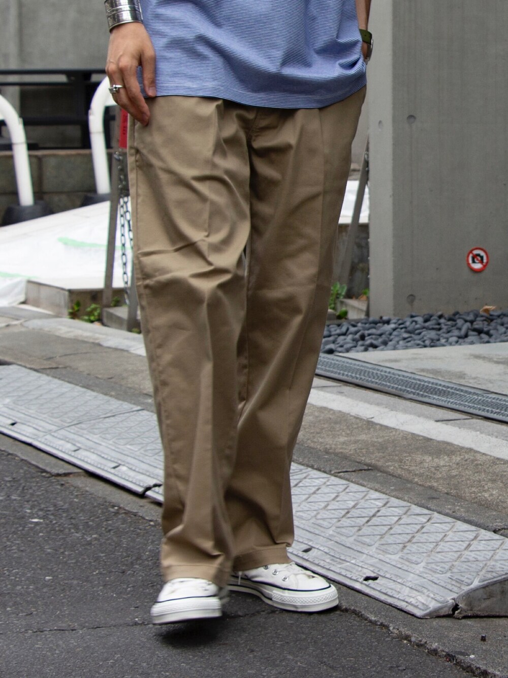 ブルー系のTシャツ/カットソー、ベージュ系のチノパンツ、ホワイト系のスニーカーを着用したメンズの夏コーディネートの2枚目の写真