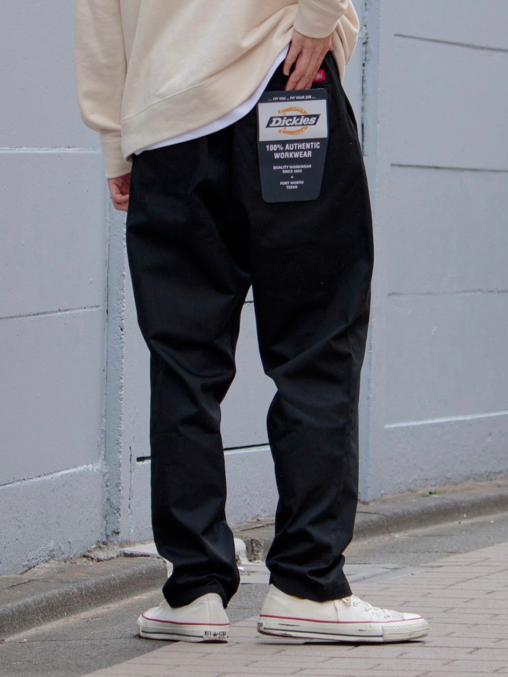 ブラック系のチノパンツ、ホワイト系のパーカー、ホワイト系のスニーカーを着用したメンズの春コーディネートの2枚目の写真