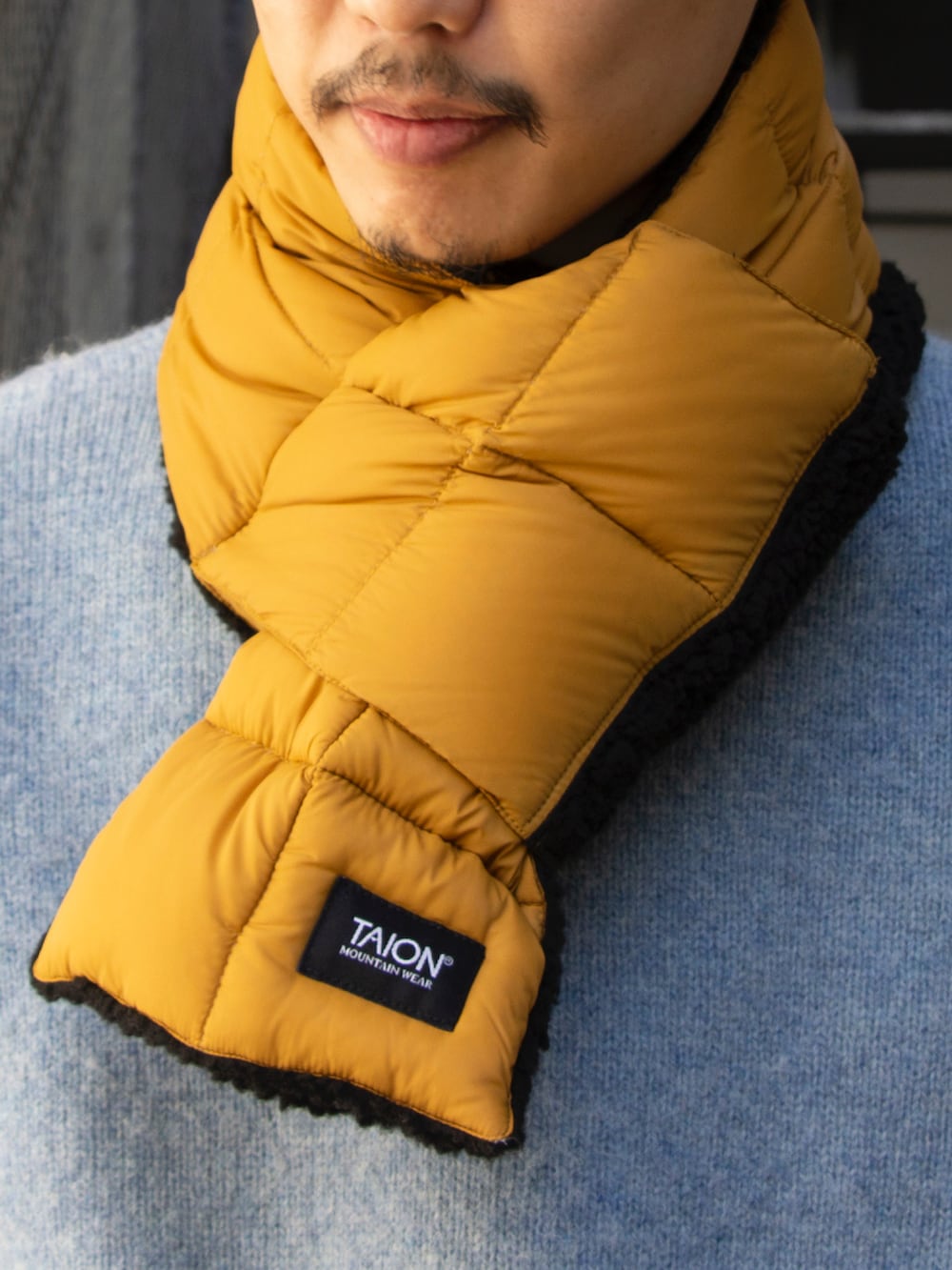 ブルー系のニット/セーター、ブルー系のチノパンツ、ブルー系のスニーカーを着用したメンズの秋コーディネートの3枚目の写真