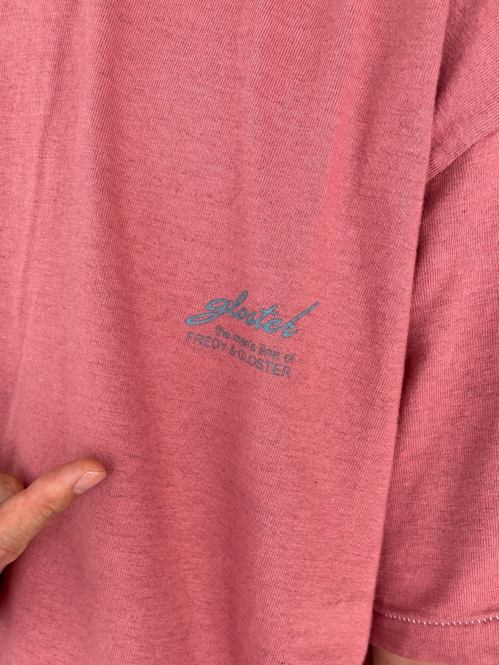オレンジ系のTシャツ/カットソー、ブラック系のサングラスを着用したメンズの夏コーディネートの4枚目の写真