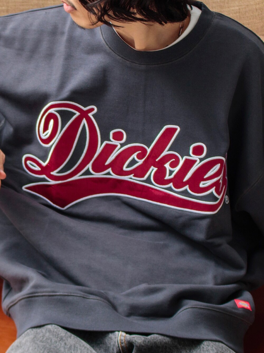 グレー系のスウェット、ブラック系のデニムパンツを着用したメンズの夏コーディネートの3枚目の写真