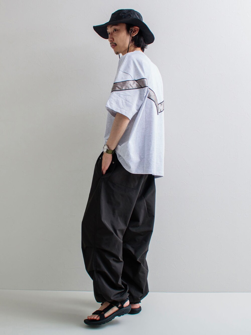 ホワイト系のTシャツ/カットソー、ブラック系のその他パンツ、ブラック系のサンダルを着用したメンズの春コーディネートの2枚目の写真