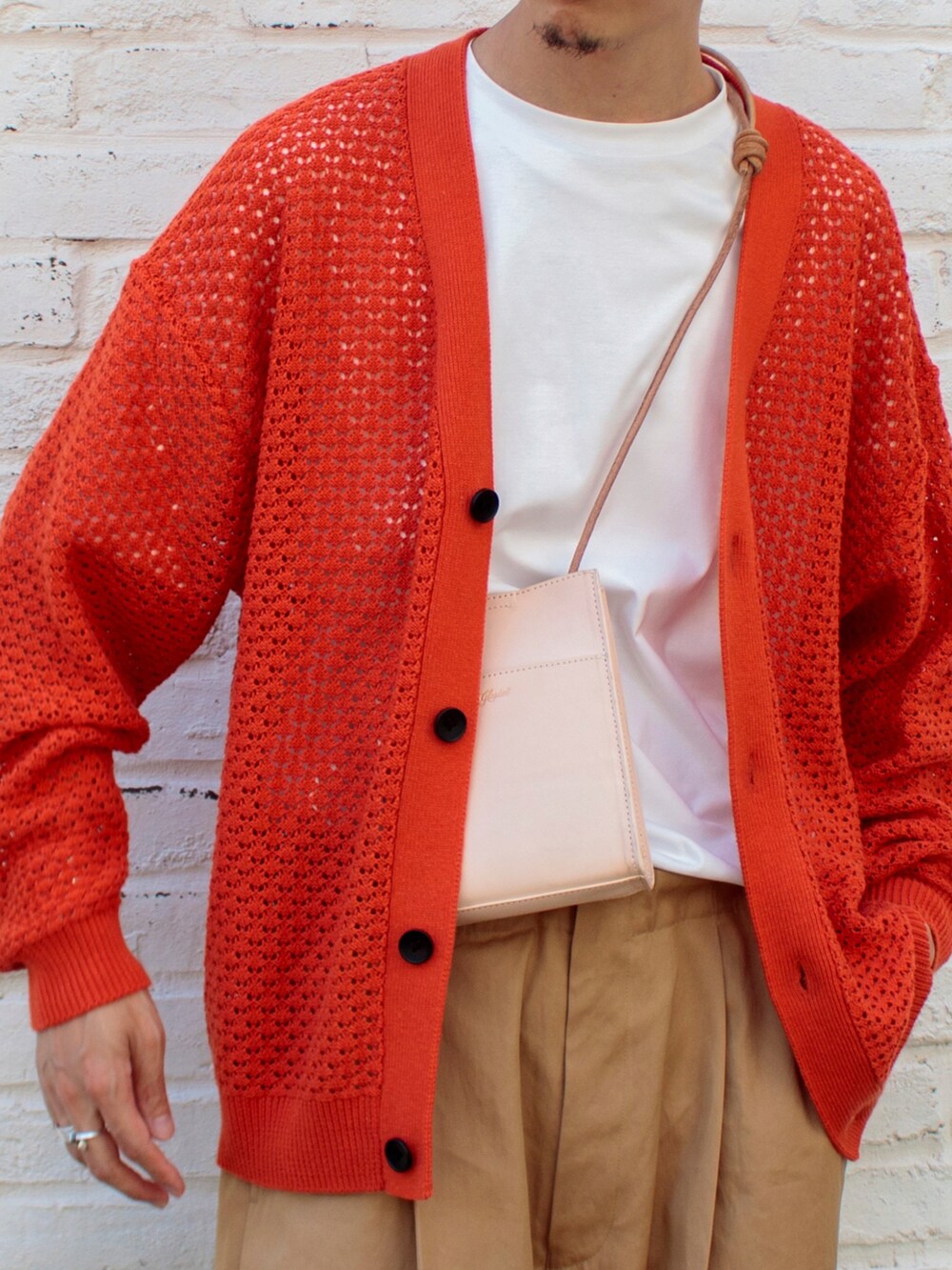 オレンジ系のカーディガン/ボレロ、ベージュ系のショルダーバッグ、ブラック系のサンダルを着用したメンズの夏コーディネートの2枚目の写真