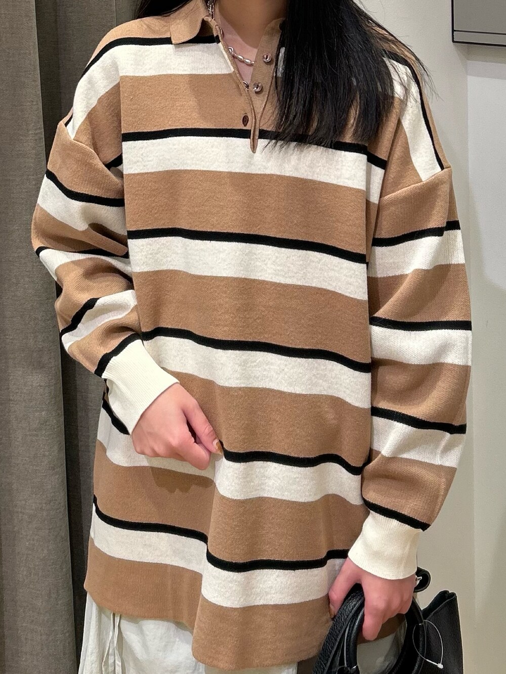 ホワイト系のスカート、ブラック系のブーツ、ベージュ系のニット/セーターを着用したレディースの秋コーディネートの4枚目の写真