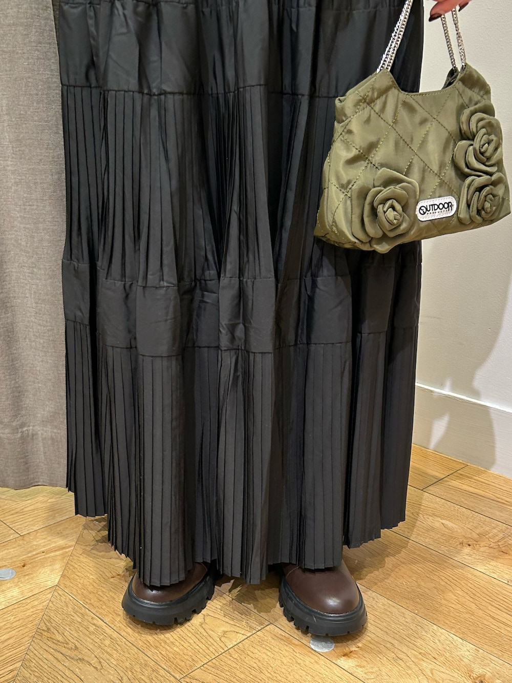 グリーン系のブルゾン、ブルー系のニット/セーター、ブラック系のスカートを着用したレディースの秋コーディネートの5枚目の写真