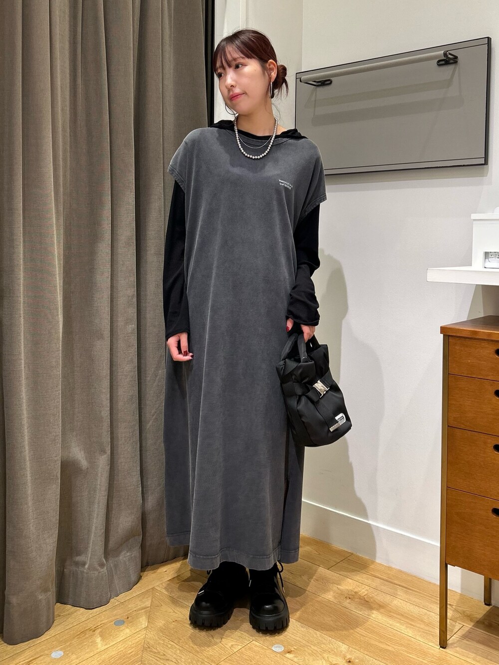 ブラック系のトートバッグ、ブラック系のワンピース、ブラック系のTシャツ/カットソーを着用したレディースの秋コーディネートの3枚目の写真