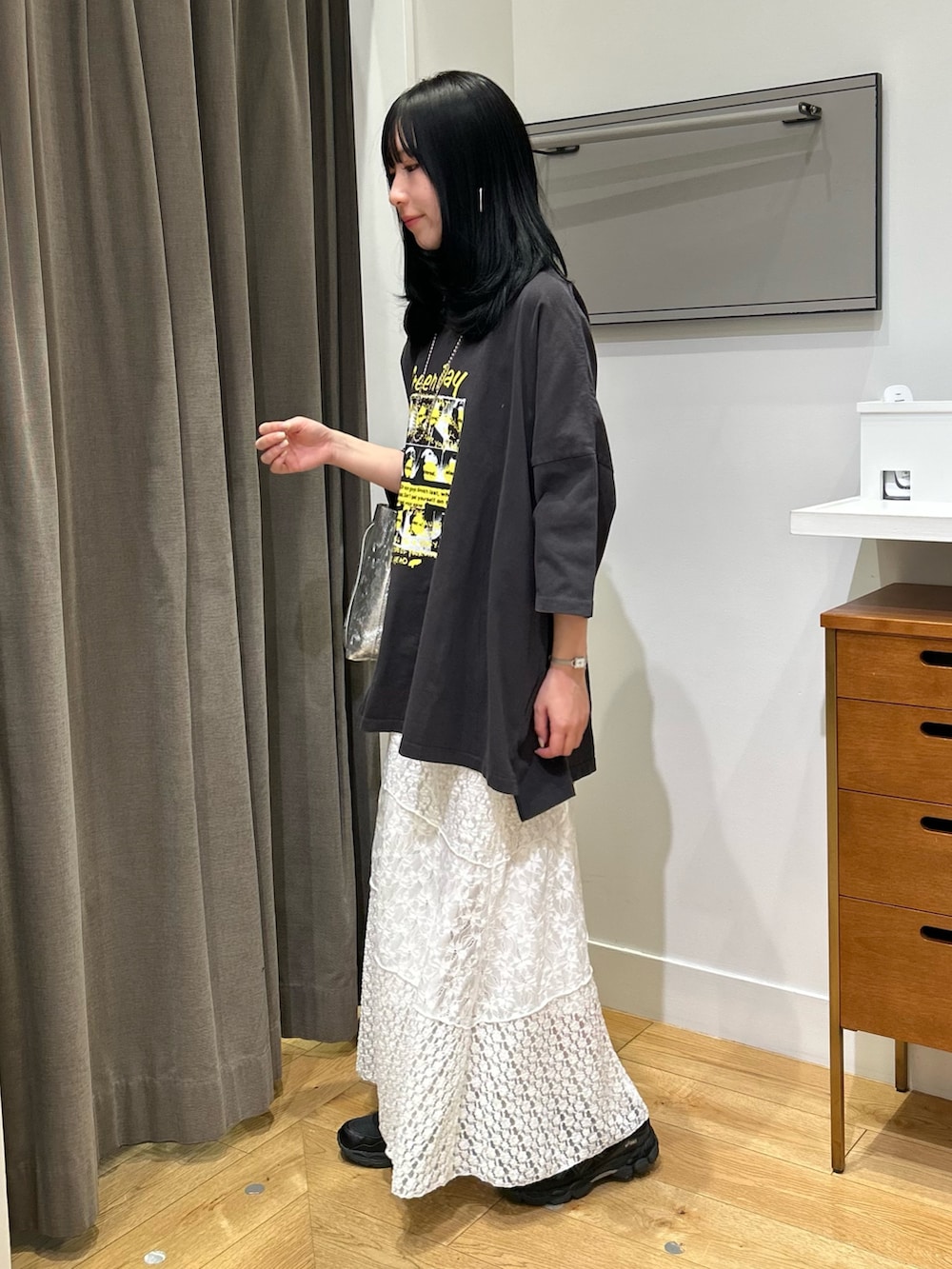 ホワイト系のスカート、ブラック系のスニーカー、シルバー系のショルダーバッグを着用したレディースの春コーディネートの2枚目の写真