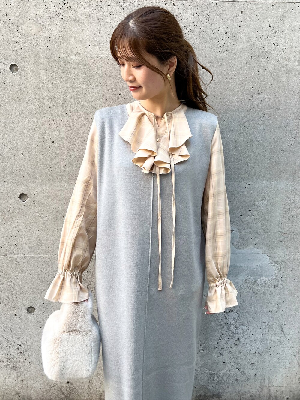 グレー系のジャンパースカート、ベージュ系のショルダーバッグ、ベージュ系のシャツ/ブラウスを着用したレディースの秋コーディネートの3枚目の写真