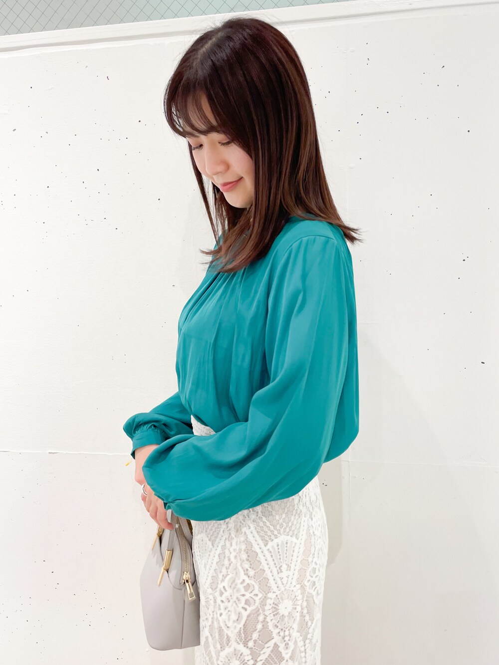 グリーン系のシャツ/ブラウス、ホワイト系のスカート、グレー系のショルダーバッグを着用したレディースの春コーディネートの4枚目の写真