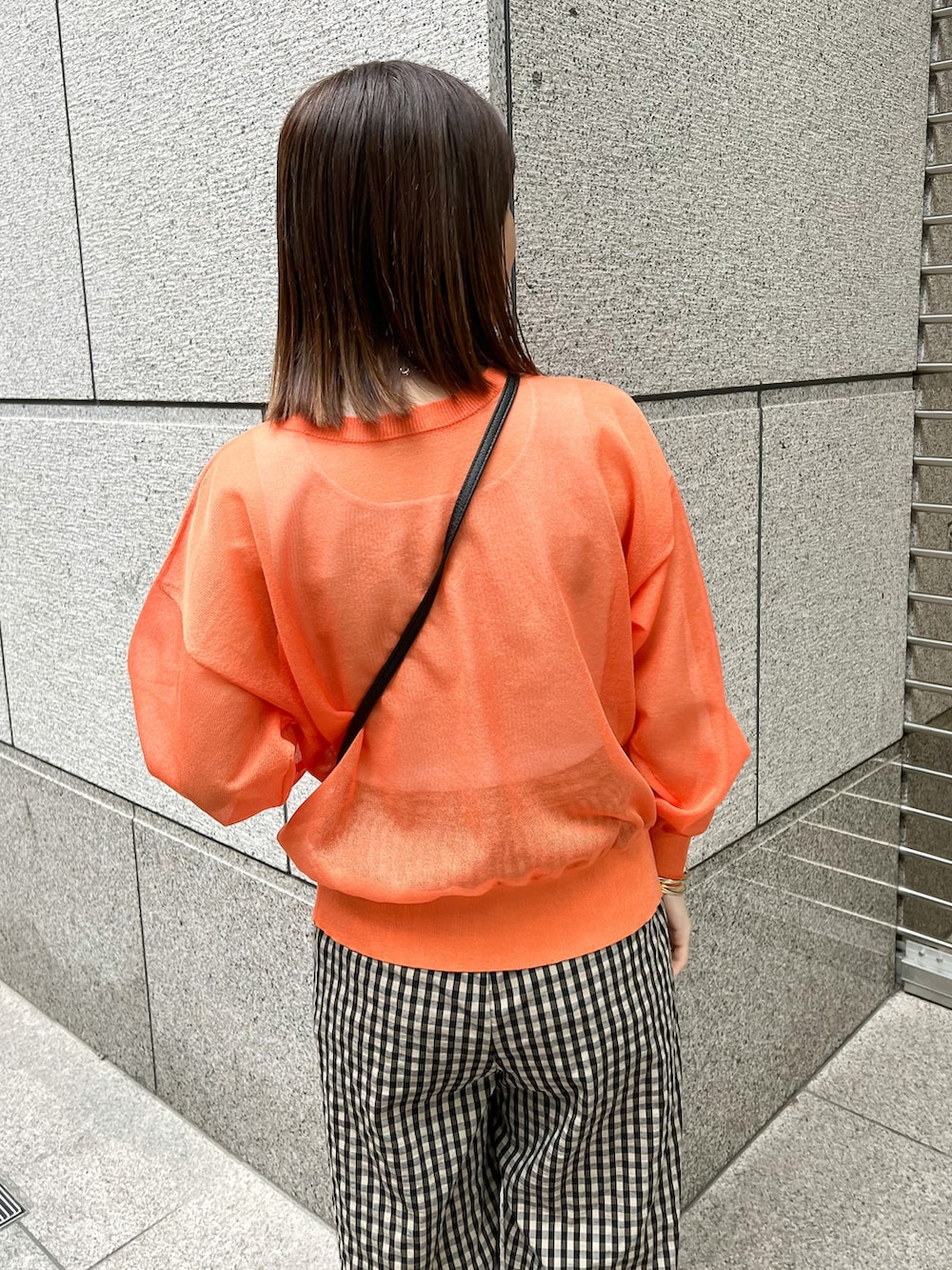 オレンジ系のカーディガン/ボレロ、ブラック系のショルダーバッグ、ブラウン系のその他パンツを着用したレディースの春コーディネートの4枚目の写真