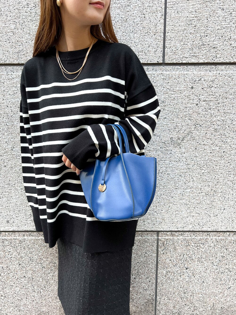 ブラック系のニット/セーター、ブルー系のショルダーバッグ、ブラック系のスカートを着用したレディースの冬コーディネートの3枚目の写真