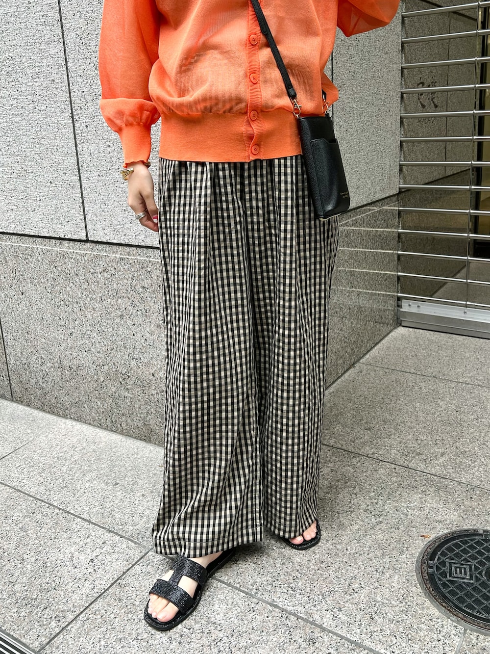 オレンジ系のカーディガン/ボレロ、ブラック系のショルダーバッグ、ブラウン系のその他パンツを着用したレディースの春コーディネートの5枚目の写真