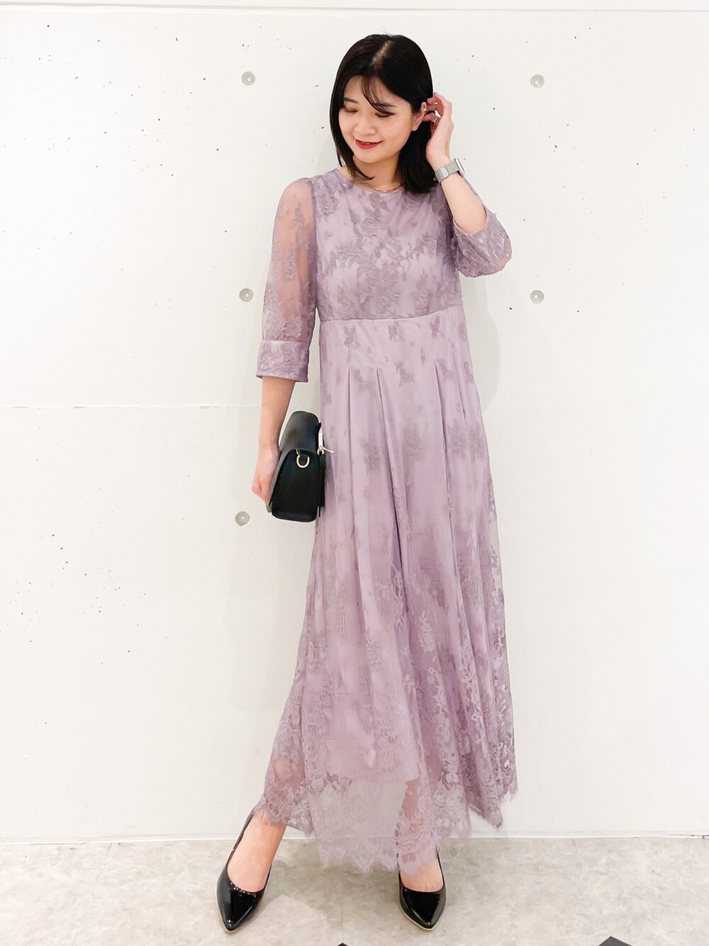 ピンク系のドレス、ブラック系のショルダーバッグ、ブラック系のパンプスを着用したレディースの冬コーディネートの2枚目の写真