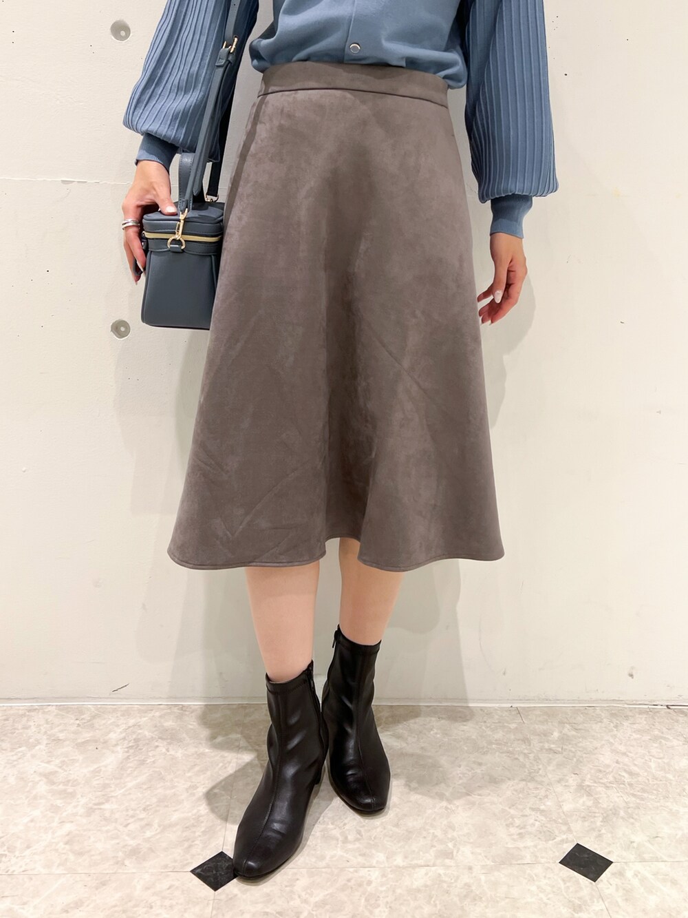 ブルー系のカーディガン/ボレロ、ブルー系のショルダーバッグ、グレー系のスカートを着用したレディースの秋コーディネートの5枚目の写真