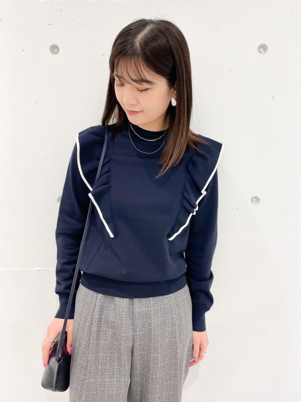 ブルー系のニット/セーター、ブルー系のショルダーバッグ、グレー系のその他パンツを着用したレディースの冬コーディネートの3枚目の写真